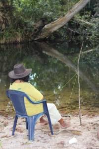 Emily Murray takes a break during a field trip to collect lawyer cane to determine if the fish were biting.  Photo D Murray Girringun Aboriginal Art Centre 2016